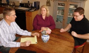 A job coach meets with an autistic adult and his guardian to create a job development plan.